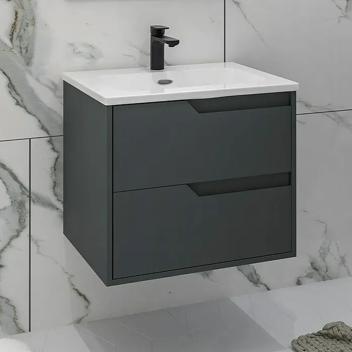 Disbain Conjunto de mueble de baño Casiopea - Ancho: 60 cm, Verde foresta, Mate - Unidad de tocador gris con dos cajones y grifo negro sobre un lavabo blanco contra una pared de mármol.