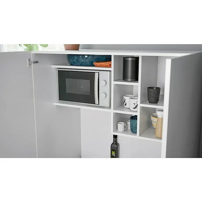 Respekta Schrankküche Peter - Breite: 104 cm, Weiß, Mit Duo-Kochmulde und Mikrowelle - Ein weißer Küchenschrank mit Mikrowelle und Regalen, auf denen Geschirr, eine Flasche und ein Lautsprecher stehen, bietet eine praktische Aufbewahrungslösung.