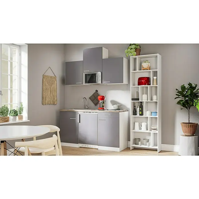 Respekta Singleküche Luis - Breite: 150 cm, Grau, Mit Glaskeramikkochfeld, Mikrowelle und Kühlschrank - Helle Küche mit grauen Schränken, weißem Regal und Holztisch, akzentuiert durch Dekorationen und Pflanzen.