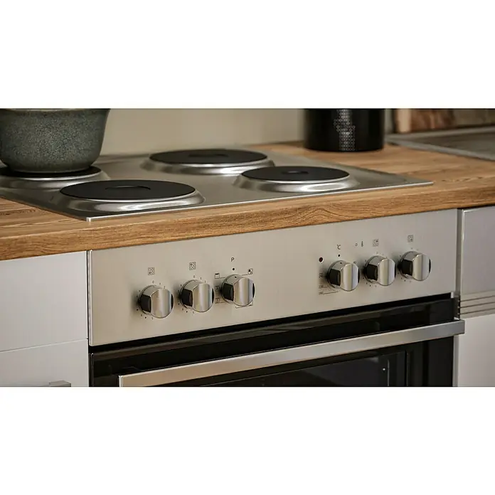 Respekta Küchenzeile Malia - Breite: 280 cm, Weiß, Mit Elektrogeräten, Dekor Arbeitsplatte: Holzoptik, Volumen Backofen: 58 l - Nahaufnahme eines modernen silbernen Elektroherds mit Kochfeld, Knöpfen und Backofentür in einer Küche.