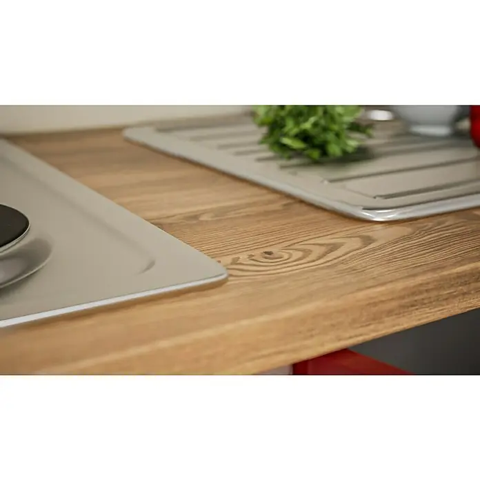 Respekta Küchenzeile Malia - Breite: 270 cm, Rot, Mit Elektrogeräten, Dekor Arbeitsplatte: Holzoptik, Volumen Backofen: 58 l - Nahaufnahme einer hölzernen Küchenarbeitsplatte mit Spüle und frischen Kräutern, die eine stilvolle und praktische Kücheneinrichtung zeigt.