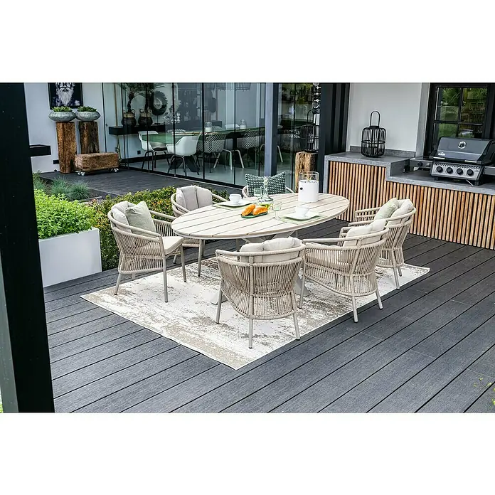 Garden Impressions Gartentisch Edison - L x B x H: 220 x 115 x 75 cm, Aluminium, Vironwood, Oval, Taupe - Outdoor-Esstischgruppe mit hellem Holztisch und beigefarbenen Geflechtsesseln auf einer Terrasse.