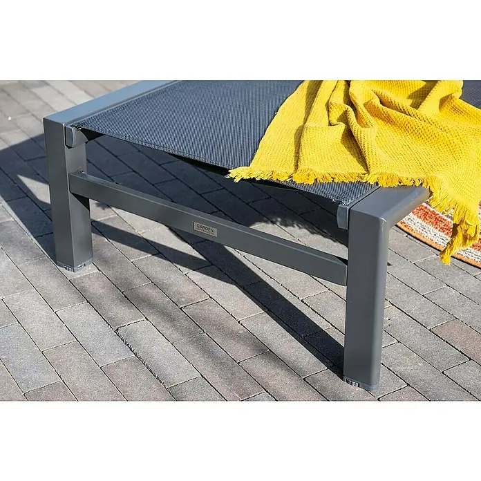 Garden Impressions Gartenliege - B x T x H: 72 x 200 x 32,5 cm, Aluminium, Schwarz/Anthrazit - Moderner grauer Aluminium-Gartenliegestuhl mit dunkler Textilene-Sitzfläche und gelber Decke auf gepflasterter Terrasse.