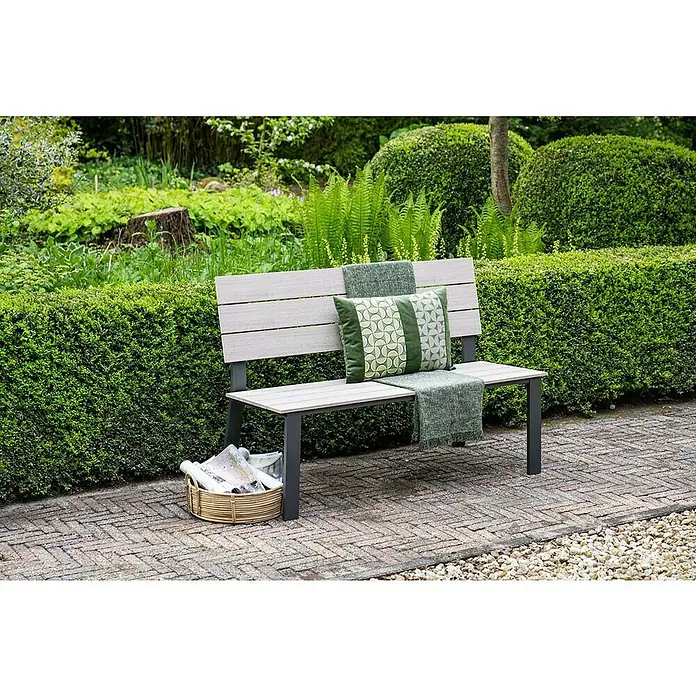 Garden Impressions Gartenbank Jondal - B x T x H: 125 x 56 x 85 cm, Aluminium, Schwarz/Weiß - Eine hellgraue und dunkelgraue Gartenbank mit einem grünen Kissen und einer Decke steht auf einer Ziegelterrasse in einem üppigen Garten.