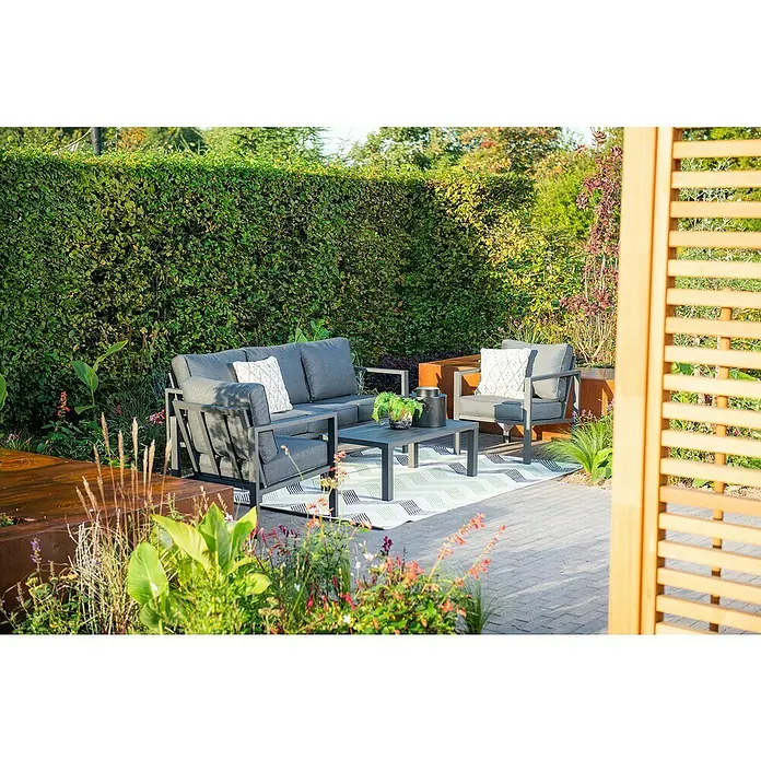 Garden Impressions Loungemöbel-Set Springs - 4 -tlg., Aluminium, Grau/Schwarz - Dunkelgraue Outdoor-Loungemöbel aus Metall mit Sofa, Sesseln und Couchtisch auf einem gemusterten Teppich im Garten.