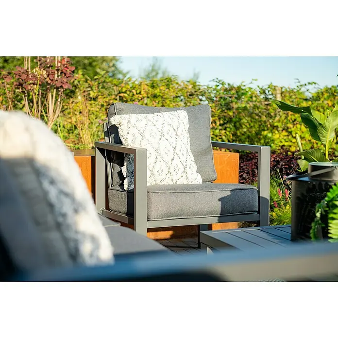 Garden Impressions Loungemöbel-Set Springs - 4 -tlg., Aluminium, Grau/Schwarz - Grauer Outdoor-Sessel mit weißem Zierkissen, Teil einer Loungesitzgruppe im Garten.