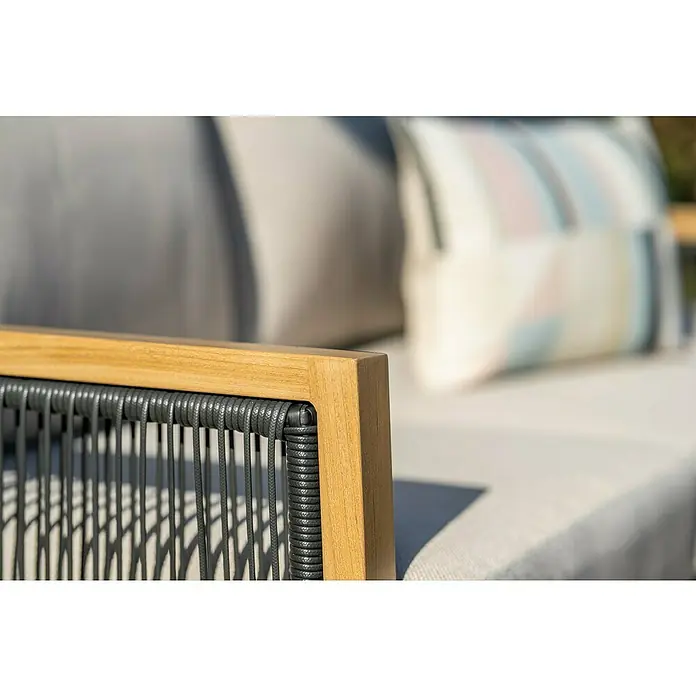 Garden Impressions Loungemöbel-Set Decala - 4 -tlg., Aluminium, Beige - Nahaufnahme einer Outdoor-Sofa-Armlehne mit Holzrahmen und dunkelgrauem Geflecht, mit unscharfen Kissen im Hintergrund.