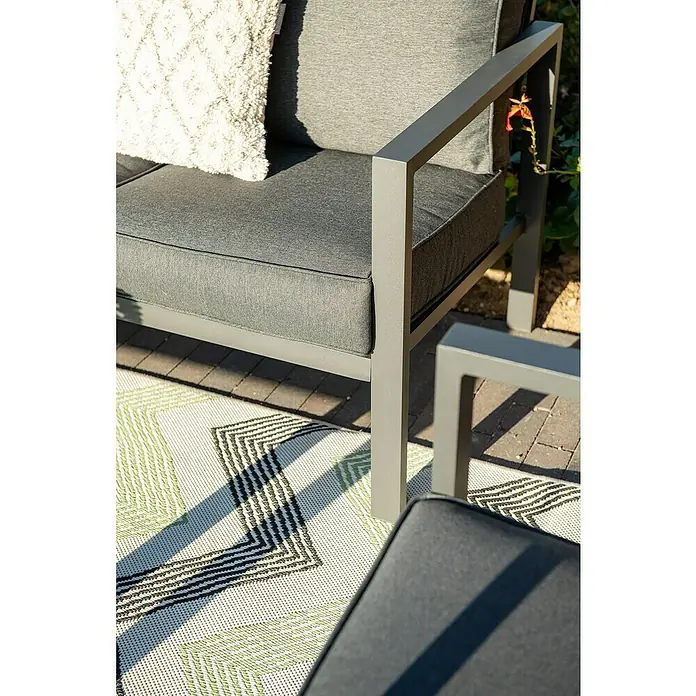 Garden Impressions Loungemöbel-Set Springs - 4 -tlg., Aluminium, Grau/Schwarz - Graues Outdoor-Metallsofa mit Stoffkissen und weißem strukturiertem Kissen auf einem gemusterten Teppich.