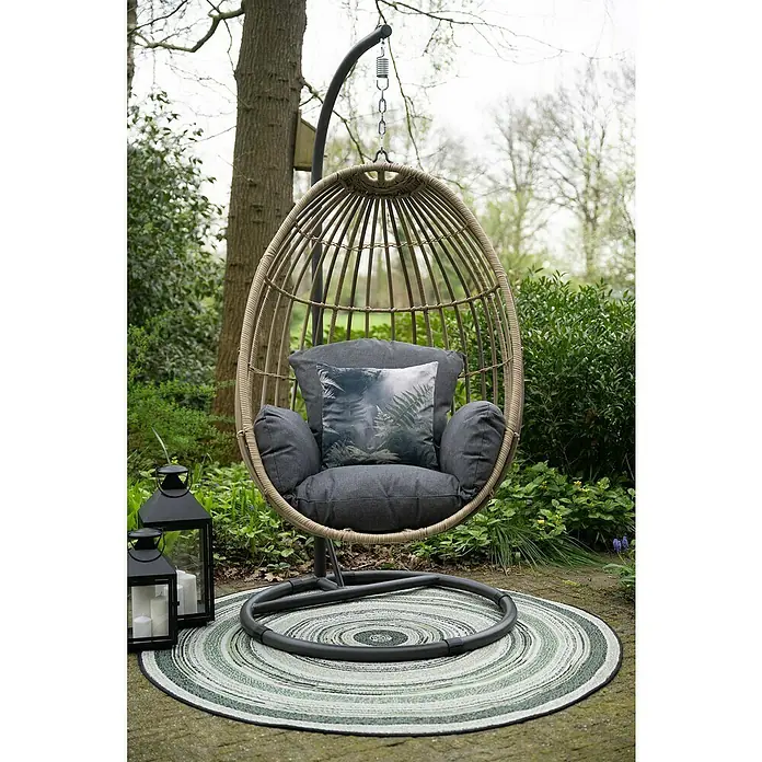 Garden Impressions Hängesessel Panama - L x B x H: 100 x 100 x 200 cm, Kunststoff, Schwarz/Beige - Outdoor-Hängesessel mit dunkelgrauen Kissen und Farnmuster-Kissen auf einem grün gestreiften runden Teppich im Garten.
