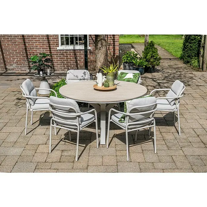Garden Impressions Gartentisch rund Edison - Ø x H: 148 x 75 cm, Aluminium, Vironwood, Taupe - Helles Outdoor-Esszimmer-Set mit rundem Tisch und sechs Stühlen auf einer gepflasterten Terrasse.