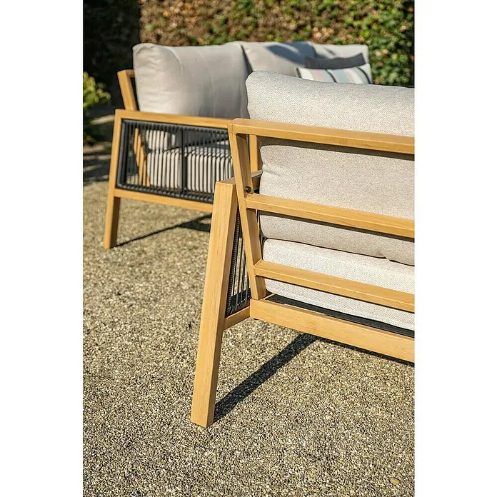 Garden Impressions Loungemöbel-Set Decala - 4 -tlg., Aluminium, Beige - Outdoor-Lounge-Sessel aus hellem Holz mit hellen Polstern und schwarzen Flechtakzenten auf Kiesboden.