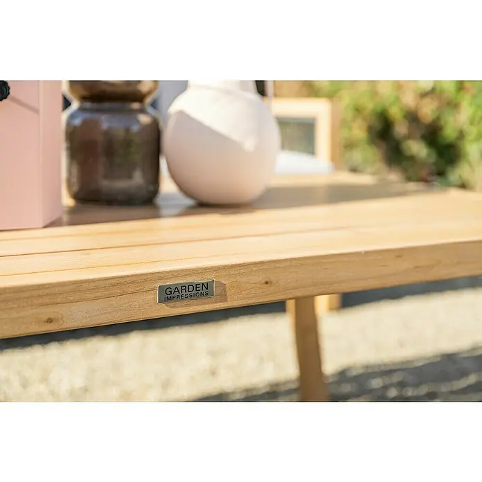 Garden Impressions Loungemöbel-Set Decala - 4 -tlg., Aluminium, Beige - Nahaufnahme eines natürlichen Holztisches mit „GARDEN IMPRESSIONS“-Etikett, mit unscharfen Dekorationsartikeln im Freien.