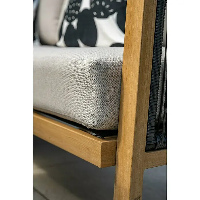 Garden Impressions Loungemöbel-Set Decala -  - Nahaufnahme eines modernen Outdoor-Sofas. Mit hellgrauem Kissen, Naturholzrahmen und dunklem geflochtenem Arm-/Rückendetail.