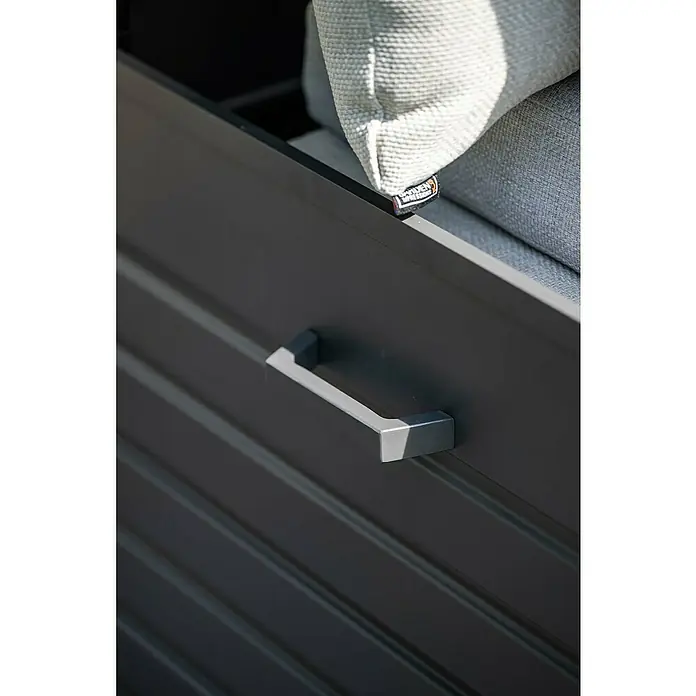 Garden Impressions Auflagenbox Primo - 155 x 97 x 825 cm, Metall, Dunkelgrau - Dunkelgraue Outdoor-Aufbewahrungsbox mit Griff, gefüllt mit hellgrauen Kissen. Ein "Garden Impressions"-Etikett ist sichtbar.
