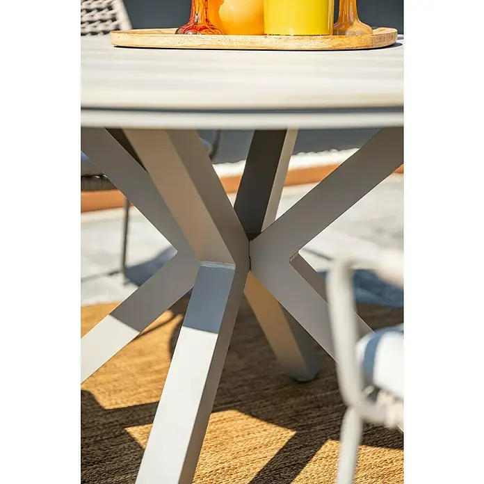 Garden Impressions Gartentisch rund Edison - Ø x H: 122 x 75 cm, Aluminium, Vironwood, Taupe - Hellgrauer Gartentisch mit X-förmigen Beinen, darauf eine Schale mit Getränken.