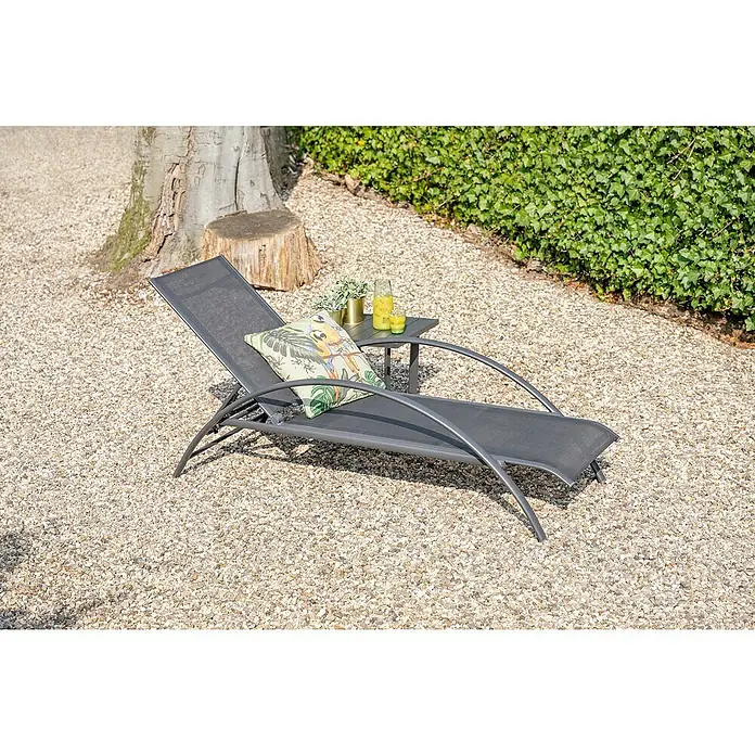 Garden Impressions Gartenliege - B x T x H: 70 x 203 x 28 cm, Aluminium, Schwarz/Anthrazit - Dunkelgraue Outdoor-Liege mit Zierkissen und Beistelltisch auf einem Kiesweg.