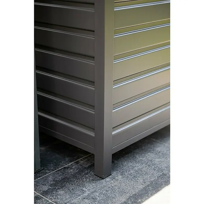 Garden Impressions Auflagenbox Primo - 155 x 97 x 825 cm, Metall, Dunkelgrau - Dunkelgraue Lamellen-Outdoor-Aufbewahrungsbox, Ecke auf dunklen Terrassenfliesen.