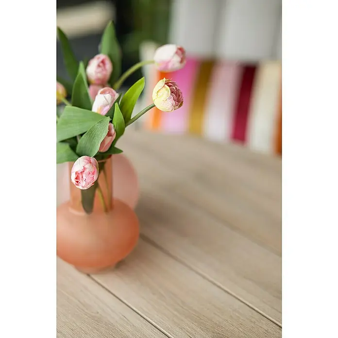 Garden Impressions Gartentisch rund Edison - Ø x H: 148 x 75 cm, Aluminium, Vironwood, Schwarz/Braun - Rosa Tulpen in einer orangefarbenen Vase auf einem hellen Holztisch.