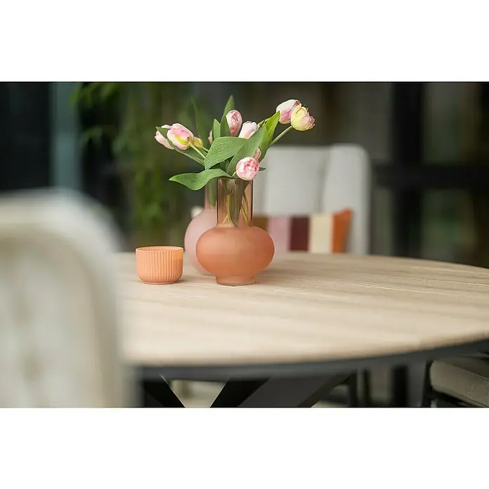 Garden Impressions Gartentisch rund Edison - Ø x H: 148 x 75 cm, Aluminium, Vironwood, Schwarz/Braun - Zwei mattierte pfirsichfarbene Vasen und ein gerippter Kerzenhalter auf Holztisch, eine Vase mit Tulpen.