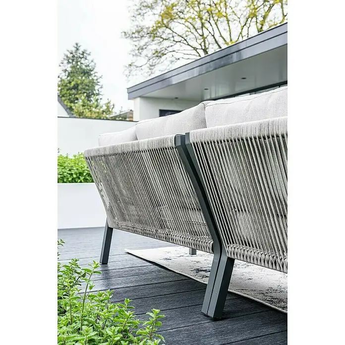 Garden Impressions Loungemöbel-Set Monti - 5 -tlg., Aluminium, Polyester, Taupe/Schwarz - Graues Outdoor-Sofa mit geflochtener Seillehne und grauen Kissen auf dunklem Holzdeck, von hinten gesehen. Moderne Outdoor-Sitzgelegenheit.