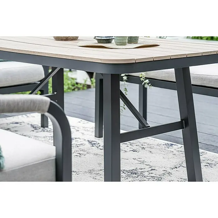Garden Impressions Loungemöbel-Set Monti - 5 -tlg., Aluminium, Polyester, Taupe/Schwarz - Ein Outdoor-Esstisch mit heller Holzplatte aus Lamellen und dunkelgrauem Metallgestell, auf einer Terrasse mit Teppich.