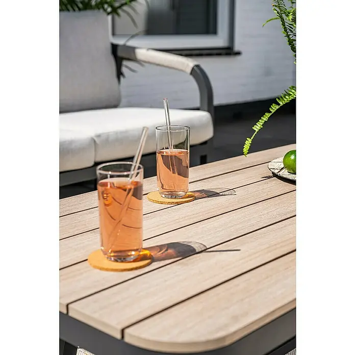 Garden Impressions Loungemöbel-Set Monti - 4 -tlg., Aluminium, Schwarz/Weiß - Gartentisch mit Holzlamellen und zwei Gläsern pinkem Getränk auf Untersetzern.