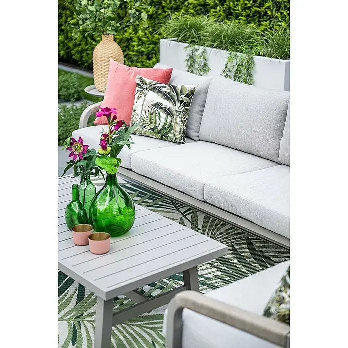 Garden Impressions Loungemöbel-Set Monti - 4 -tlg., Aluminium, Beige - Outdoor-Sofagarnitur mit hellgrauen Kissen und grauem Latten-Couchtisch auf tropischem Teppich.