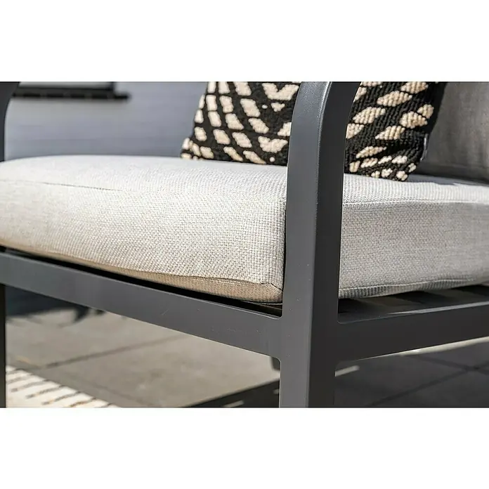 Garden Impressions Loungemöbel-Set Monti - 4 -tlg., Aluminium, Schwarz/Weiß - Nahaufnahme eines Outdoor-Sessels mit dunkelgrauem Metallrahmen und hellgrauen Stoffkissen, akzentuiert durch ein schwarz-weiß gemustertes Zierkissen.