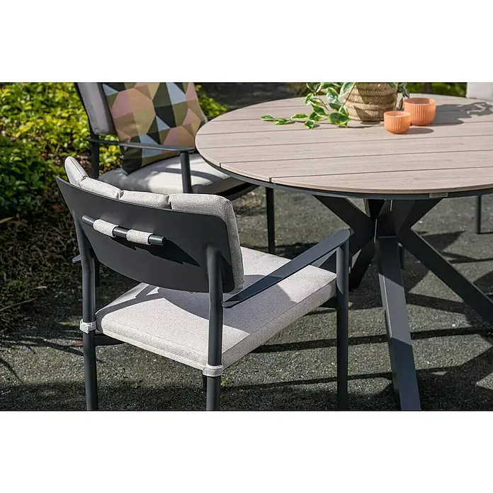 Garden Impressions Gartentisch rund Edison - Ø x H: 122 x 75 cm, Aluminium, Vironwood, Schwarz/Braun - Grauer Terrassenstuhl mit hellen Polstern und runder Gartentisch mit Holzoptikplatte und dunkelgrauem Gestell.