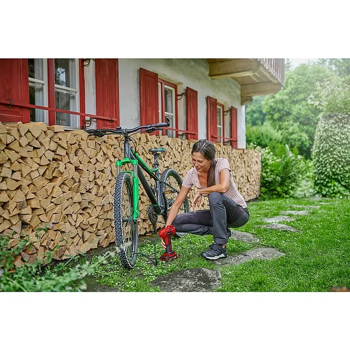 Einhell Power X-Change 18V Akku-Kompressor CE-CC 18 Li-Solo - 18 V, Ohne Akku, 11 bar - Frau pumpt einen Fahrradreifen mit einem tragbaren Einhell Akku-Kompressor auf. Ideal für unterwegs, um den Reifendruck schnell anzupassen.