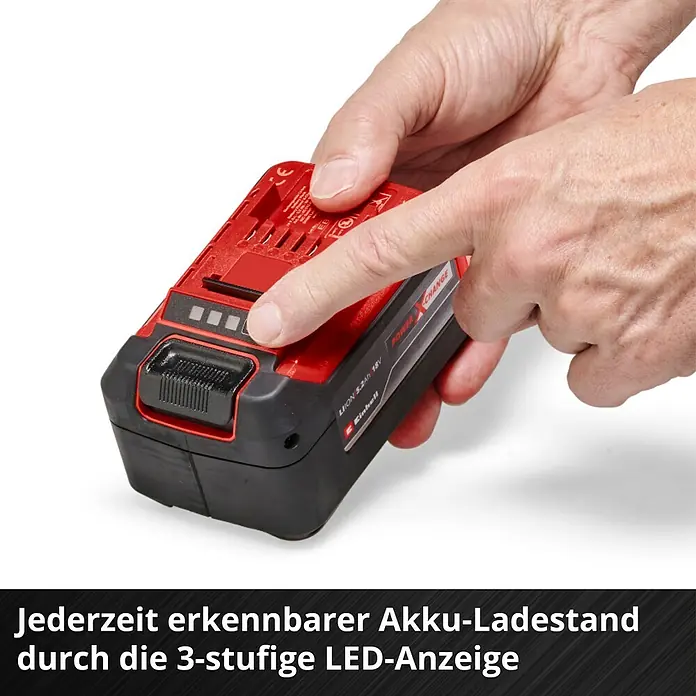Einhell Power X-Change 18V Akku-Set PXC Plus Twinpack - 18 V, 5,2 Ah, 2 Akkus - Akku-Ladestandsanzeige: Eine Hand drückt auf den Knopf einer roten Einhell 18V 5.2Ah Power X-Change Batterie, um den Ladestand anzuzeigen.