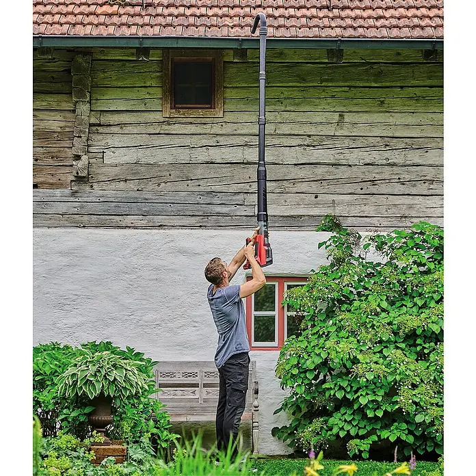 Einhell Professional Akku-Laubbläser GP-LB 18/200 Li GK-Solo - 18 V, Ohne Akku, Blasgeschwindigkeit: 200 km/h, Blasleistung: 670 m³/min - Ein Mann reinigt eine Dachrinne mit einem teleskopierbaren Dachrinnenreiniger. Das lange Rohr reicht bis zur Dachrinne, um Blätter und Schmutz zu entfernen.