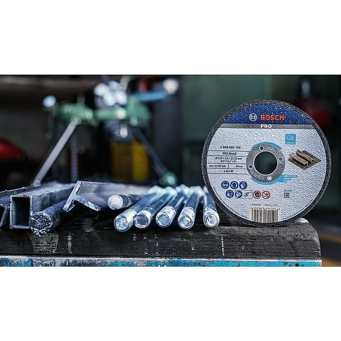 Bosch Trennscheibe A 30 S BF - Stärke Scheibe: 2,5 mm, Geeignet für: Stahl, Gerade - Nahaufnahme einer Bosch Pro Metallscheibe und Metallstücke auf einer Werkbank.