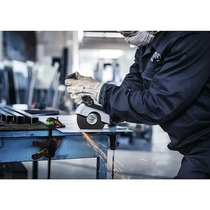 Bosch Trennscheibe Inox Rapido - Durchmesser Scheibe: 125 mm, Stärke Scheibe: 1 mm, 10 Stk. - Ein Arbeiter benutzt eine Bosch-Trennschleifer zum Schneiden von Metall, wobei Funken sprühen. Sicherheit geht vor mit Maske und Handschuhen.
