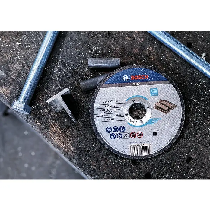 Bosch Trennscheibe A 30 S BF - Stärke Scheibe: 2,5 mm, Geeignet für: Stahl, Gerade - Nahaufnahme einer Bosch Pro Metall Trennscheibe auf einer Werkbank, umgeben von Metallstücken und Werkzeugen.