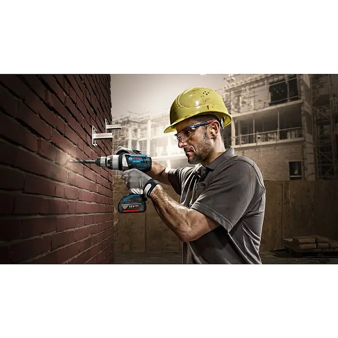 Bosch Beton- & Steinbohrer CYL-5 - Durchmesser Bohrer: 6 mm, Arbeitslänge: 50 mm - Ein Bauarbeiter bohrt mit einem Bosch-Akkuschrauber Löcher in eine Ziegelwand, um Halterungen anzubringen.