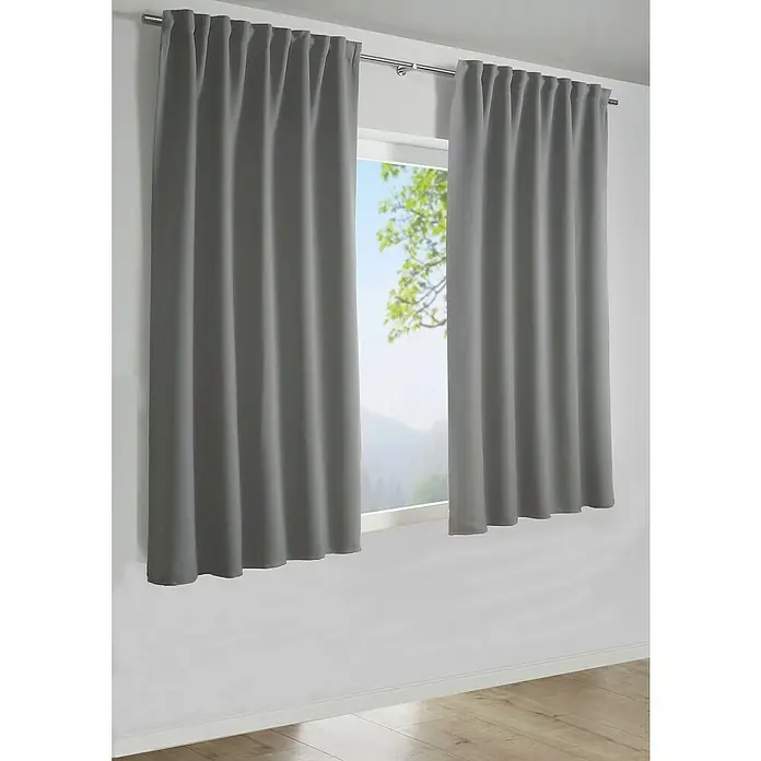 Schlaufenschal Dimout - B x H: 245 x 140 cm, Polyester, Grau - Graue Verdunkelungsvorhänge aus Stoff hängen an einer silbernen Gardinenstange vor einem Fenster mit Blick auf eine grüne Landschaft.