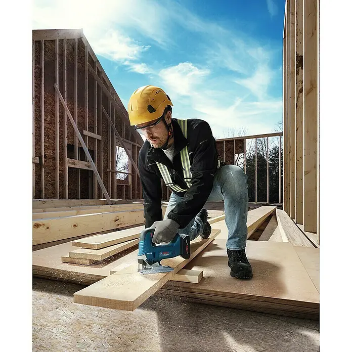 Bosch Professional AMPShare 18V Akku-Pendelhubstichsäge GST 18V-125 B - 18 V, Ohne Akku, Leerlaufhubzahl: 0 /min - 3.500 /min - Ein Bauarbeiter benutzt eine Bosch Stichsäge zum Holzzuschnitt, mit persönlicher Schutzausrüstung auf einer Baustelle.