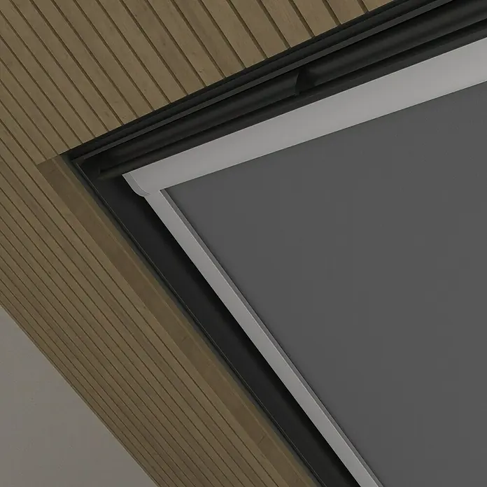 Dachfensterrollo Sky 2.0 - M08, Dunkelgrau, Manuell - Nahaufnahme einer grauen Rollo in einem Dachfenster, umgeben von Holzverkleidung, die Lichtschutz und Privatsphäre bietet.