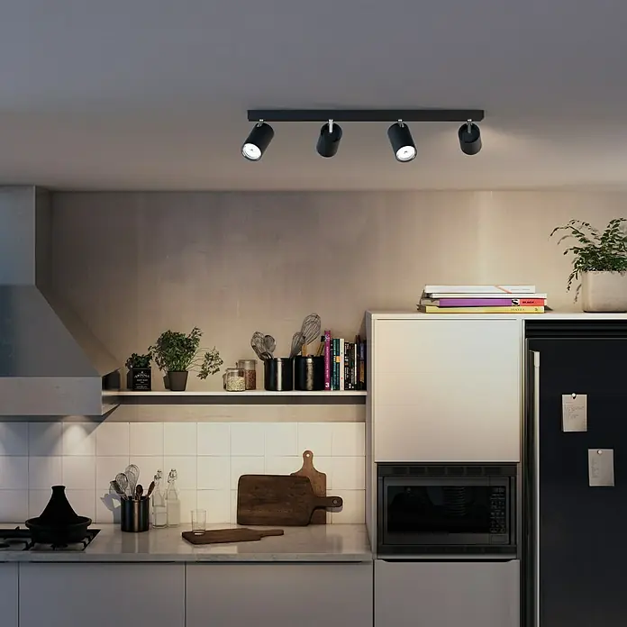 Philips Regleta Kosipo - 5,5 W, L x An x Al: 9,2 x 62,8 x 11,8 cm, Negro, GU10, 4 ud. - Escena de cocina con un foco de techo LED Philips Hue negro con cuatro luces que dirigen la luz a la superficie de trabajo.