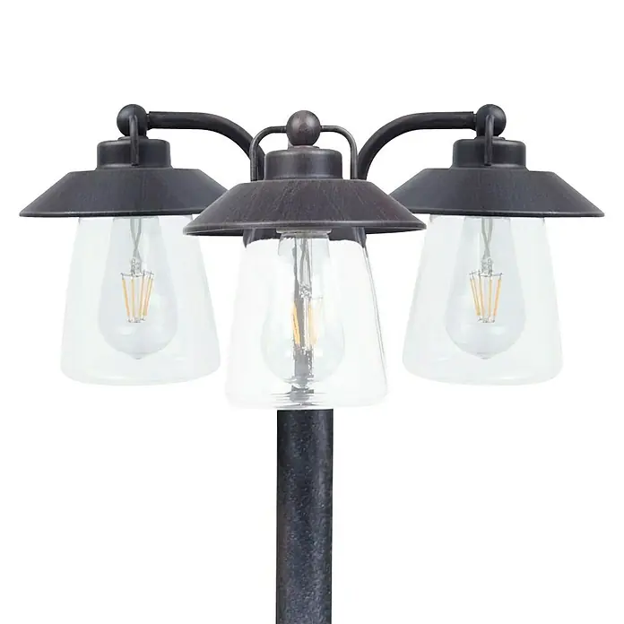 Lutec Farola Cate - 60 W, Color del marco: Antracita, 43 x 43 x 190 cm, Sin bombillas - Primer plano de una lámpara de exterior de tres luces con pantallas de vidrio transparente y un acabado rústico.