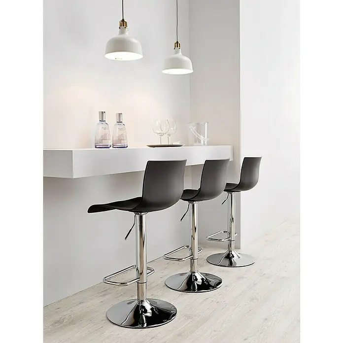 Taburete de cocina Nico - Negro - Esta foto muestra tres taburetes de bar con asientos oscuros y estructuras cromadas ubicados frente a una barra elegante y minimalista.