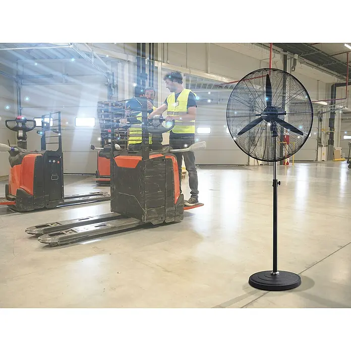 Purline Venty Ventilador de pie Metablast - Negro, 75 cm, 190 cm - Un ventilador de pie en un almacén, proporcionando una brisa fresca. Perfecto para días de trabajo calurosos, mejorando la circulación del aire.