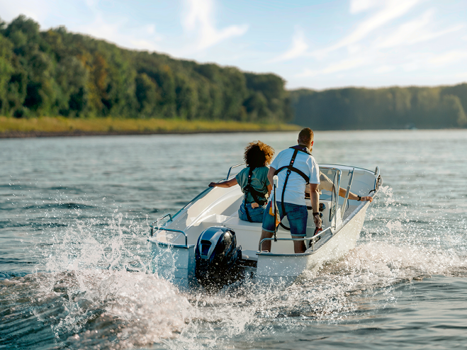 2 Personen sind auf einem Boot mit Motor auf einem See