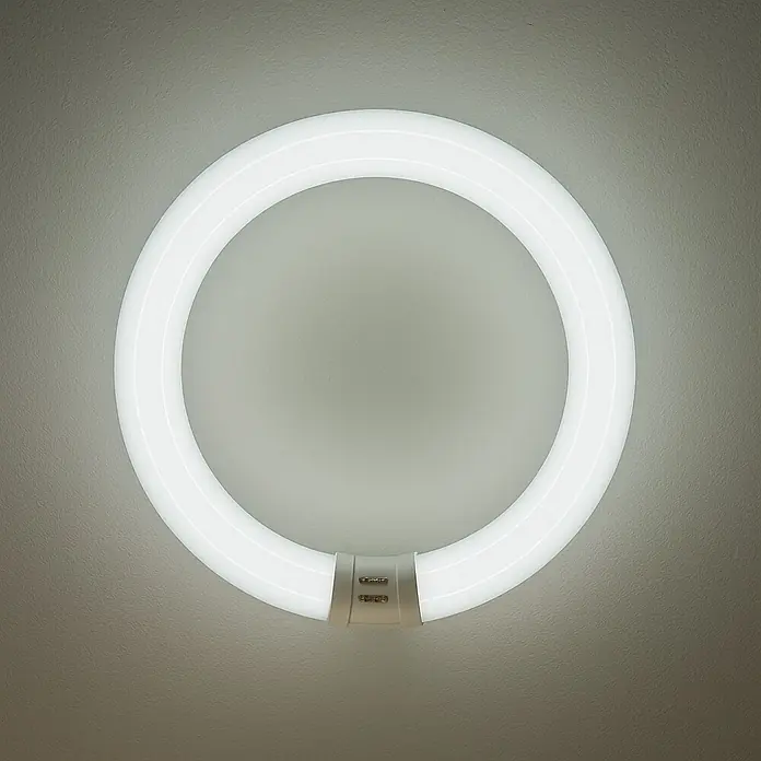 Osram Tubo fluorescente - Largo: 40 cm, Blanco frío, 40 W, 2.900 lm, G10q - Primer plano de una luminaria LED de anillo redonda y brillante montada en una pared, que emite una iluminación uniforme y brillante.
