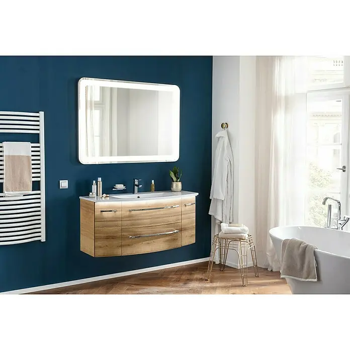 Camargue Badmöbel-Set - Berg Eiche, Matt, 120 cm, 4 -tlg., 29,6 W - Ein modernes Badezimmer mit einem beleuchteten Spiegel über einem Waschtisch mit Holzstruktur. Die Wand ist in einem tiefen Blauton gehalten.