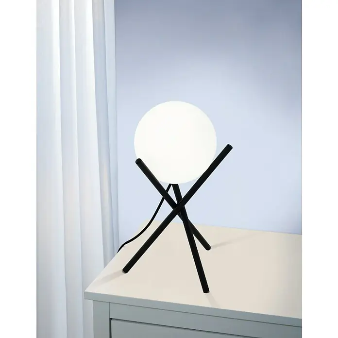 Eglo Lámpara de sobremesa Castellato - 28 W, Ø x Al: 15 x 33 cm, Negro, E14 - Este primer plano muestra una lámpara de mesa moderna con una pantalla esférica y una base de trípode negra colocada en una mesita de noche blanca.