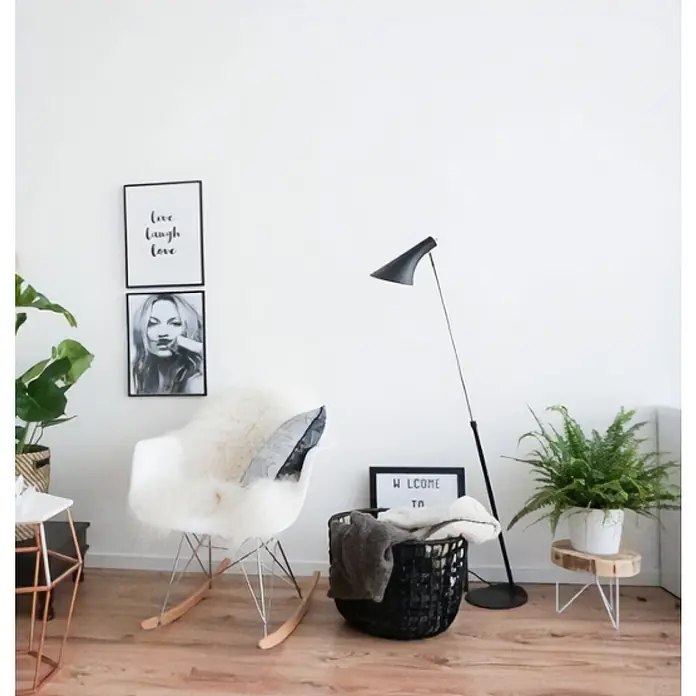 Nordlux Vanila Lámpara de pie - 40 W, Altura: 129 cm, Negro, E14 - Decoración luminosa de la sala de estar con una mecedora con piel, una lámpara de pie y plantas de interior que crean un ambiente acogedor y elegante.