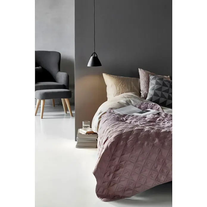 Nordlux Lámpara colgante redonda Strap 16 - 35 W, Ø x Al: 165 x 170 mm, Negro, GU10 - Elegante interior de dormitorio con un elegante sillón gris y una cama con una colcha acolchada decorativa en un suave tono rosado.