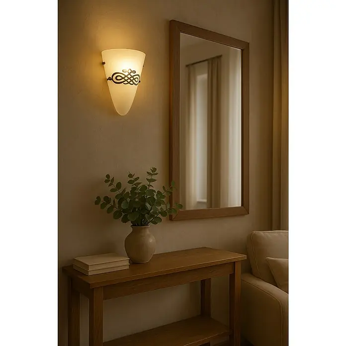 Tween Light Wandleuchte Fontana - 60 W, Braun, Weiß, E27 - Elegante Wandleuchte mit verziertem Glasschirm und Spiegel über einem Holztisch, dekoriert mit Pflanzen und Büchern, schafft eine warme Raumatmosphäre.
